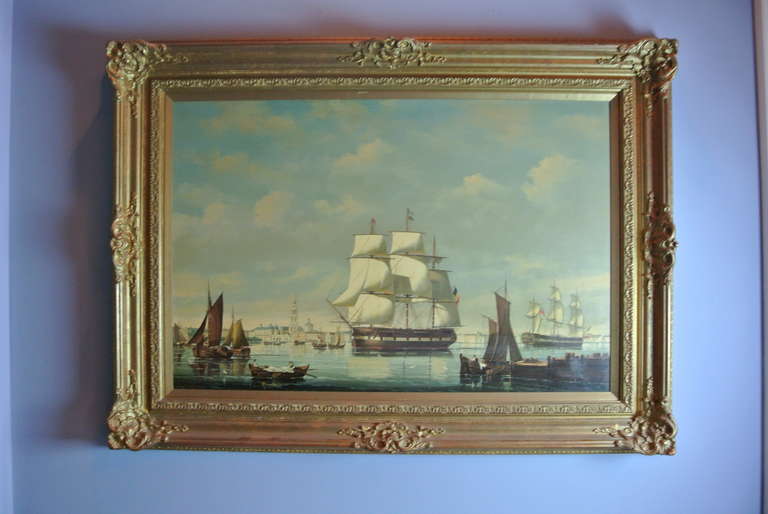 Nautical painting with several vessels and buildings in the distance. Gold leaf frame.