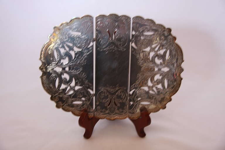 Silver Trivet with scrolling pattern open work.
Closed, length of 10.5 inches, open length 13.0inches.