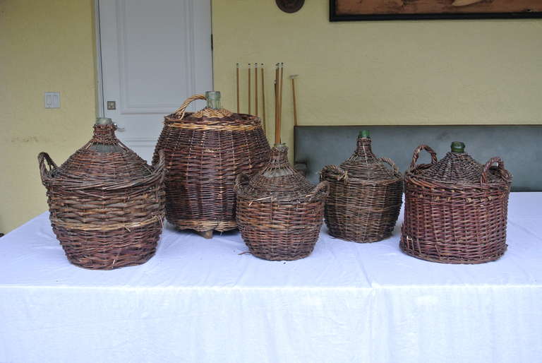 Great set of antique wicker and glass wine jugs with much character and patina.