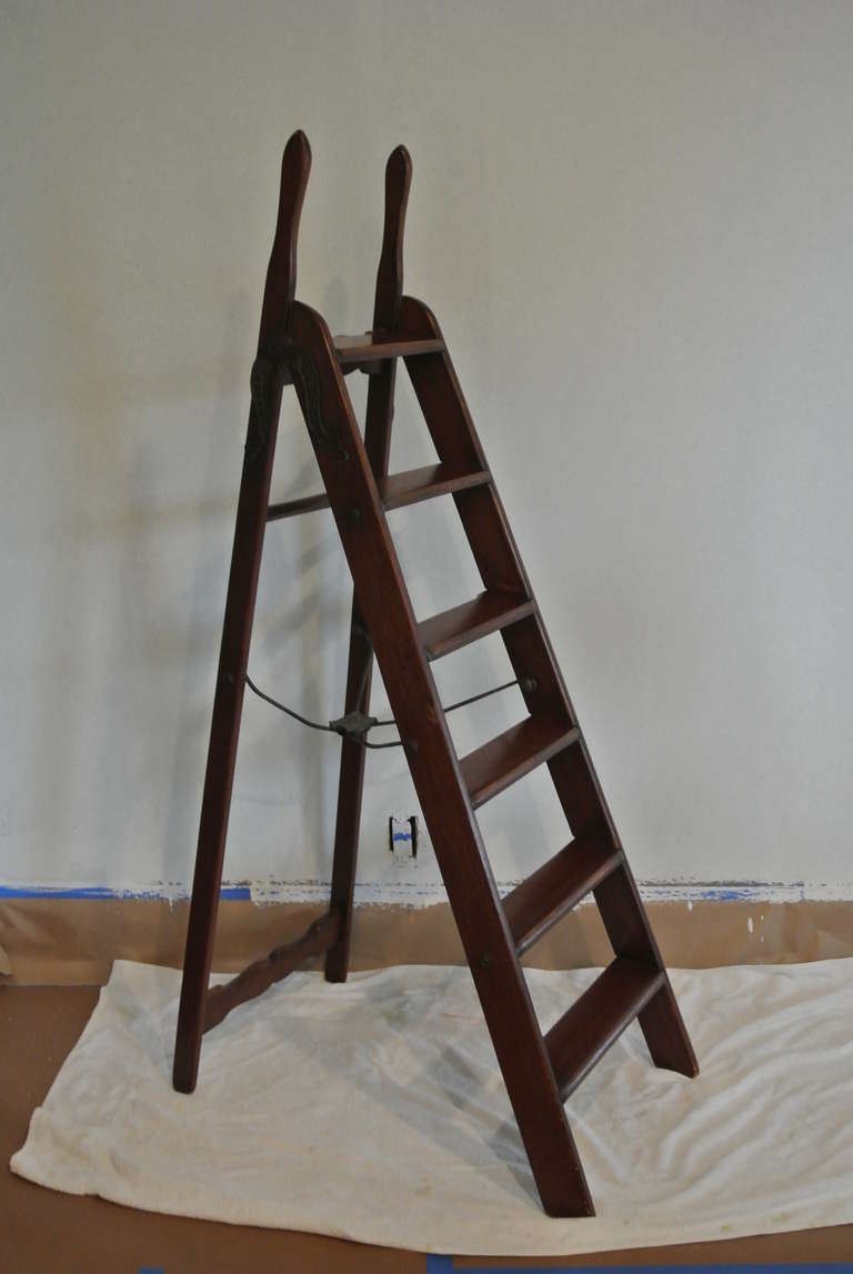 Antique library ladder. Scissor hinges on the sides read,