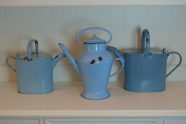 Three blue tin ware decanters with handles and lids.