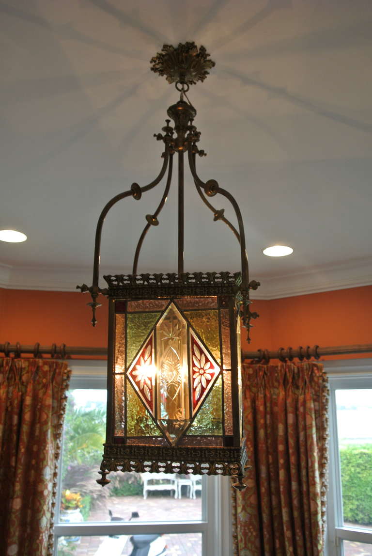 Stained glass and brass hanging light.There is a diamond shaped floral etched glass center surrounded by pastel glass panels. Beautiful deep detailing in the brass work frame and crown.