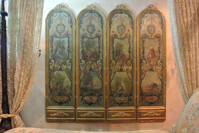 Fantastic Louis style four panel screen that has been painted in with romantic scenery. Each ribbon tied arched frame encloses a panel with two registers of 