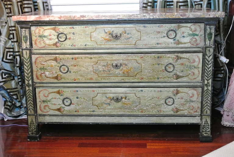Antique venetian chest of drawers with breathtaking original painted decoration. Resplendent in antique putty green with cherubs, flowers and garlands. Old bronze drawer pulls and I believe the original marble top. Marble top has swirling clouds of