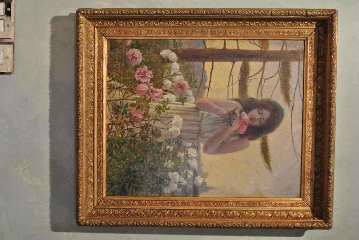 Ethereal oil on canvas of dreamy young lady among lilac heirloom roses taking in the roses rich fragrance. Late afternoon glowing light in background. Signed and dated lower left corner. 
Dated 1906