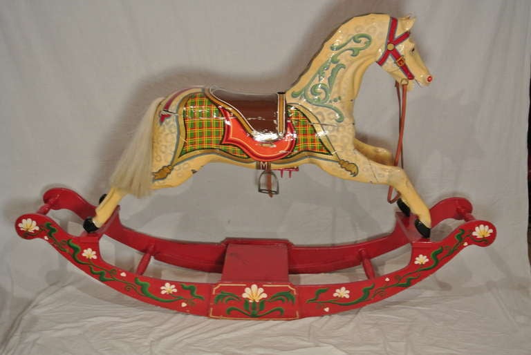 Late 19th century to early 20th century rocking horse carousel horse mounted on a later rocking mechanism. horse is painted in a cream ground with poly chrome detail. Real horse hair mane and tail.