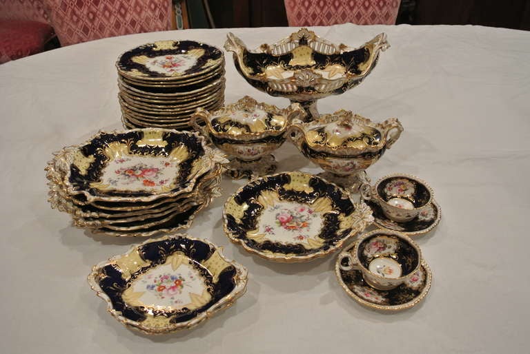 33 pieces of cobalt blue and yellow botanical desert service made in England by the coalport factory consisting of:
1 centerpiece
2 sauce tureens w/ lids and undertrays
2 shell form biscuit trays
4 rectangular shaped bicuit trays
2 marquis