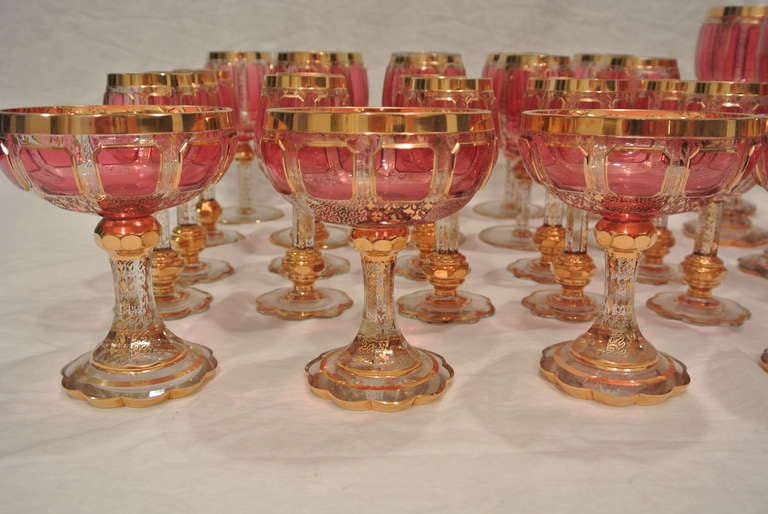 19th Century Bohemian Cranberry and Gilt Overlay Stemware Service For Sale