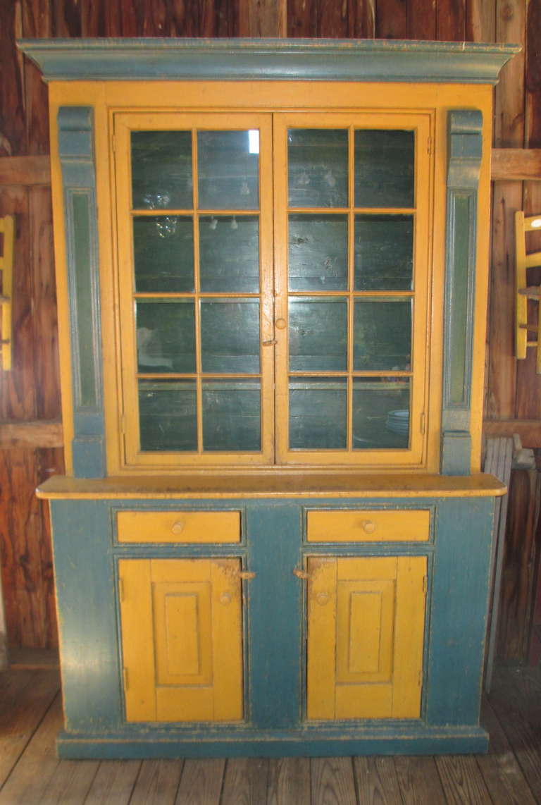 Multi-color setback cupboard with glass doors.