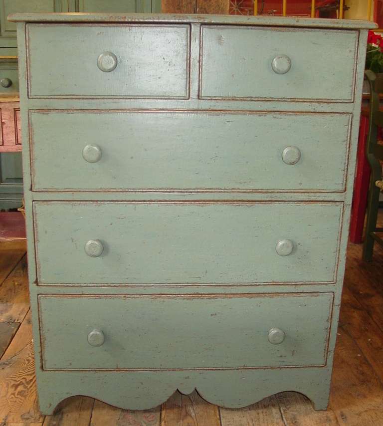 A five drawer dresser with a scalloped base