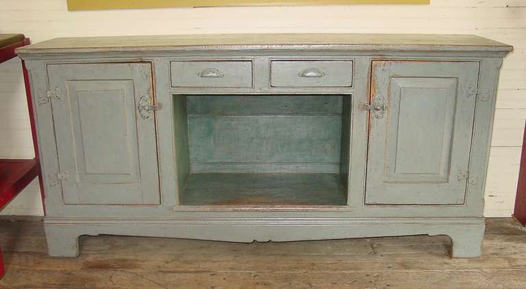 A buffet with two doors flanking an open shelf, great for displaying baskets or pottery.