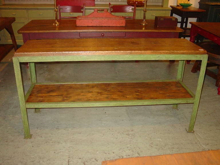 A iron base industrial table workbench with a wooden top and shelf