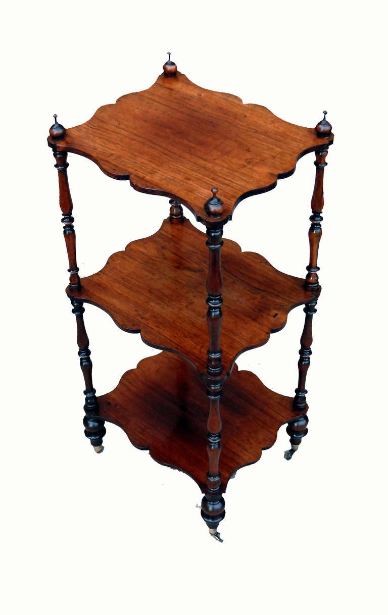 A superb quality mid-19th century rosewood
whatnot having three unusually shaped tiers
supported by elegant turned upright supports and
original brass cup castors.