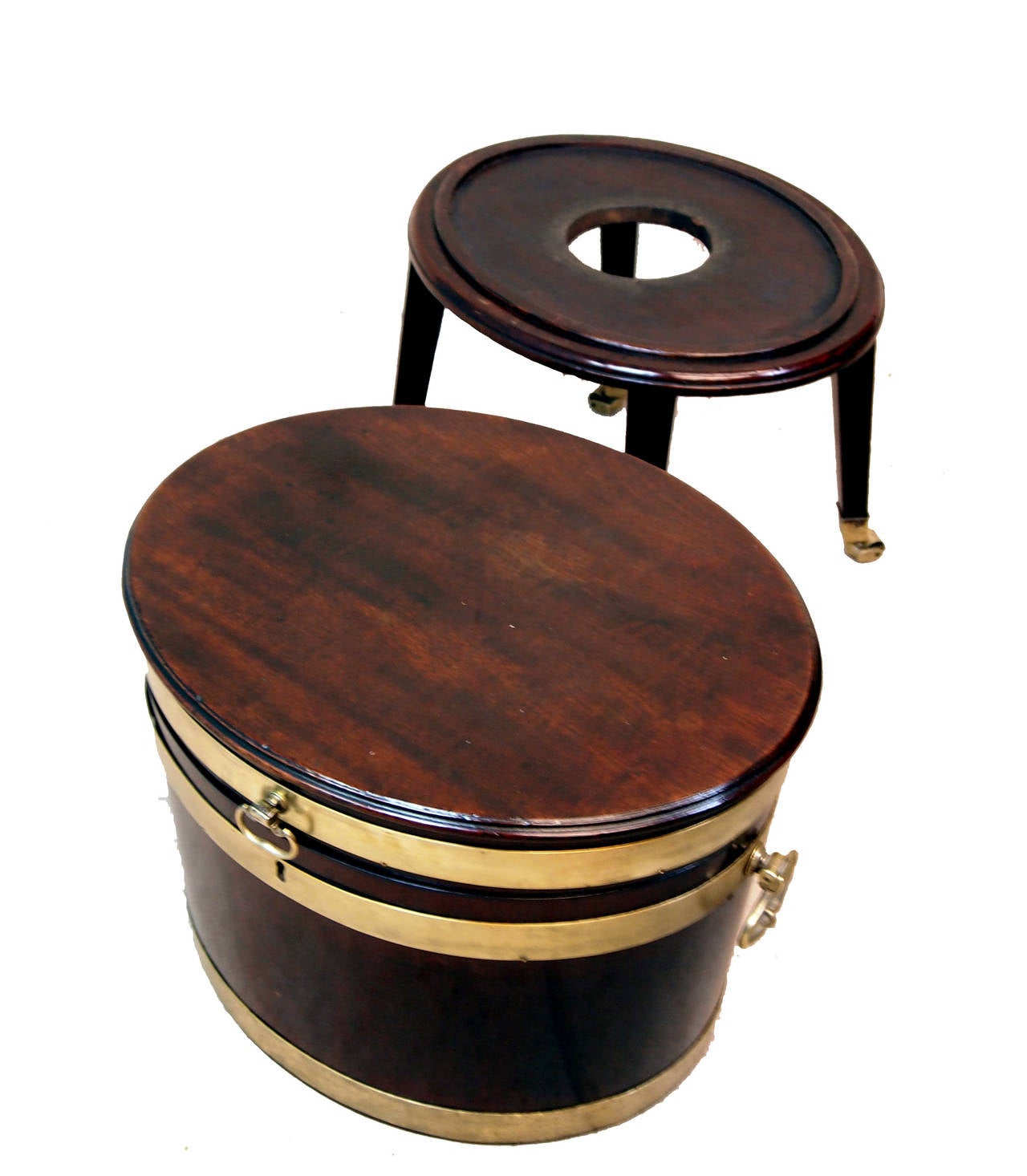 A fine quality George III period mahogany oval wine cooler having
well figured hinged lid, original brass axe drop handles and
original brass bound decoration housed on original square
tapered leg stand.