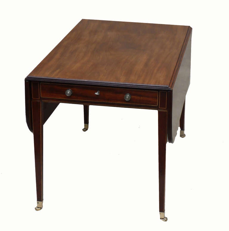 A Good Quality And Unusually Large Late 18th 
Century Mahogany Pembroke Dining Table Having
Well Figured Top With Two Hinged Flaps Over One
Drawer And One False Drawer Raised On Elegant 
Square Tapered Legs With Brass Cap Castors

(This table