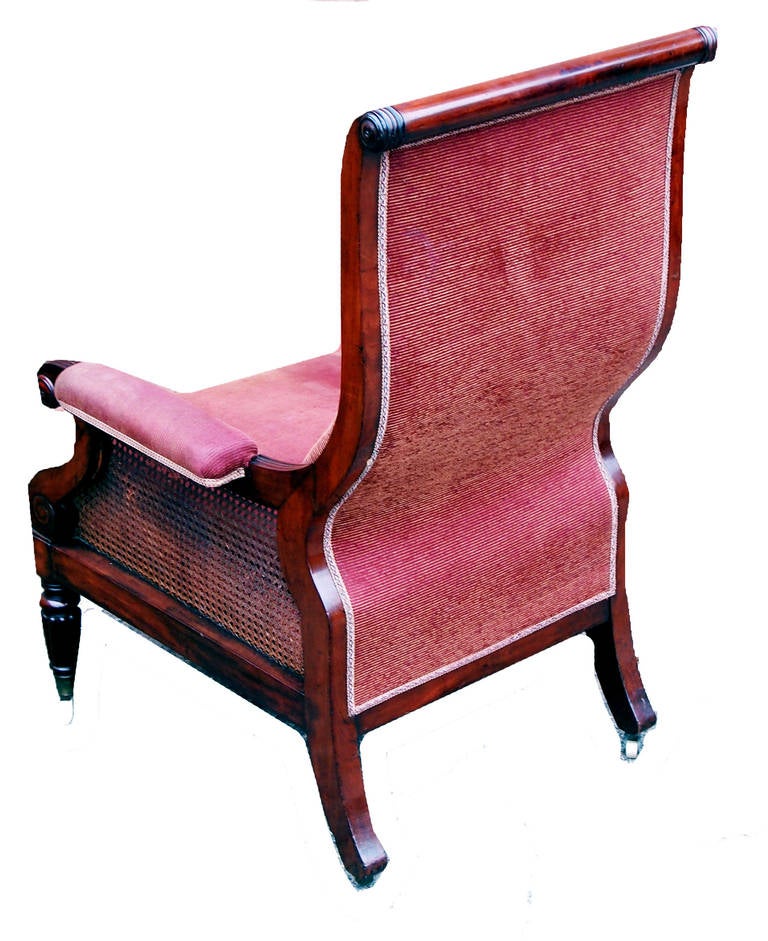 A Very Good Quality Regency Period Mahogany Library Chair 
Having Attractive Swept Back With Channeled Supports Above 
Elegant Scrolling Arms And Caned Panels To Side Raised On Fine 
Turned And Fluted Legs With Original Brass Castors