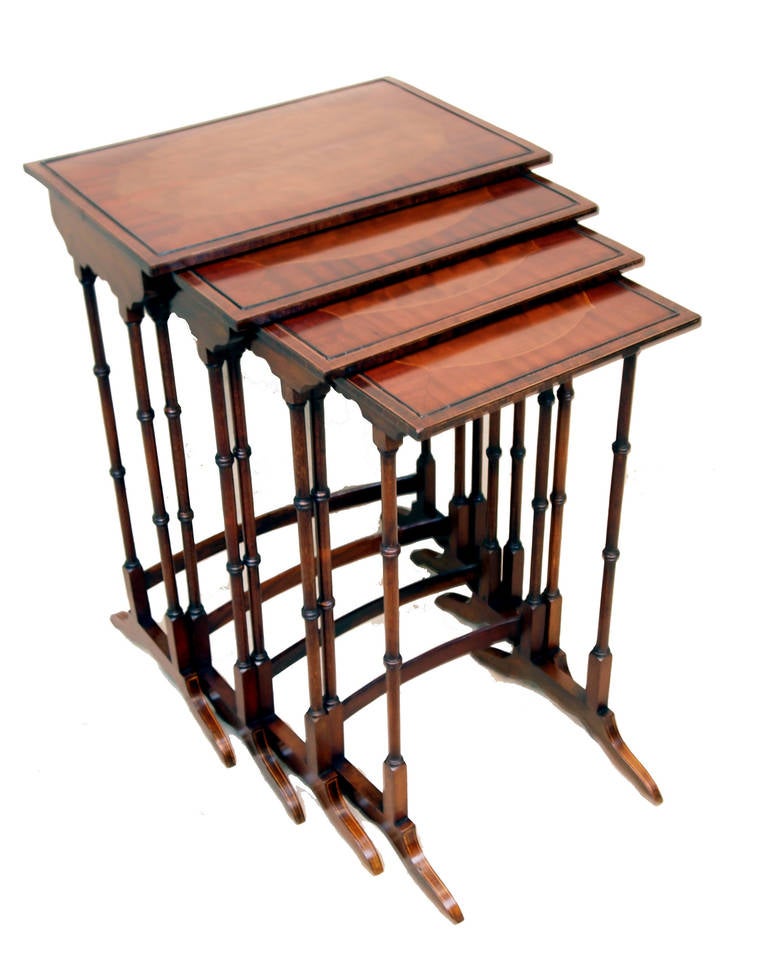 A fine quality nest of four mahogany Quartetto tables having
well figured segmented and crossbanded tops with inlaid
decoration raised on turned upright supports.