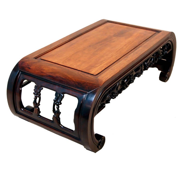 A delightful mid-19th century oriental hardwood opium coffee table having very well figured paneled top and curved ends with profuse pierced and carved decoration throughout.