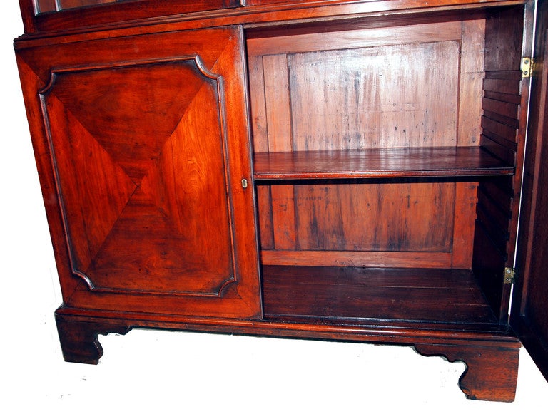 A fine Chippendale period mahogany library bookcase
having architectural pediment with dental cornice
above pair of elegant astragal glazed doors with pair
of panelled doors below standing on original shaped
bracket feet.