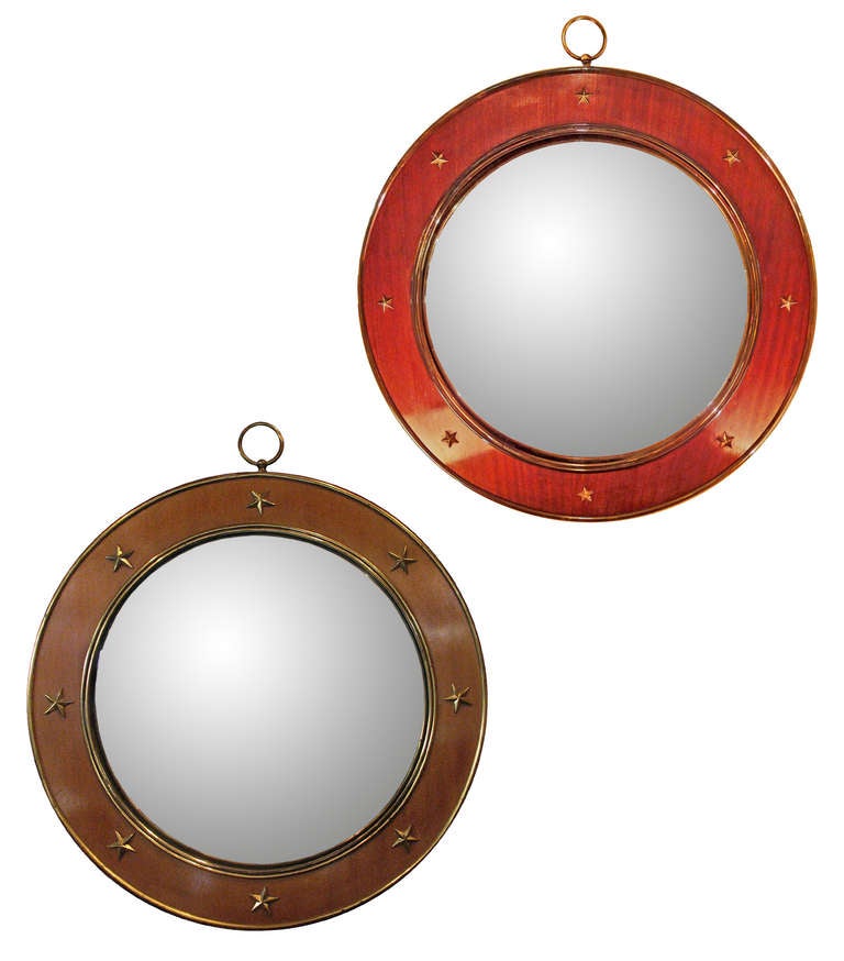 Two convex mirrors with mahogany frames decorated with gilded metal stars.