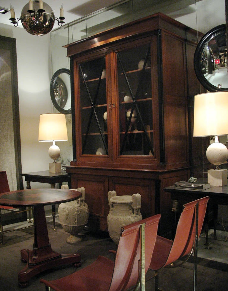 A Directoire bookcase in oak and decorated with ebonized columns and two glazed-doors.