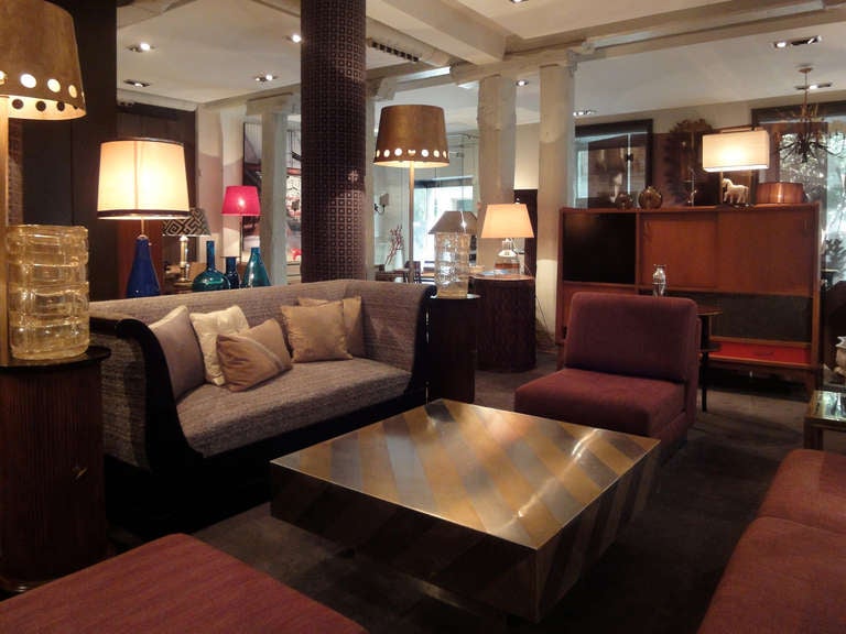 A square-shaped and low coffee-table made of polished-metal & brass diagonal stripes.