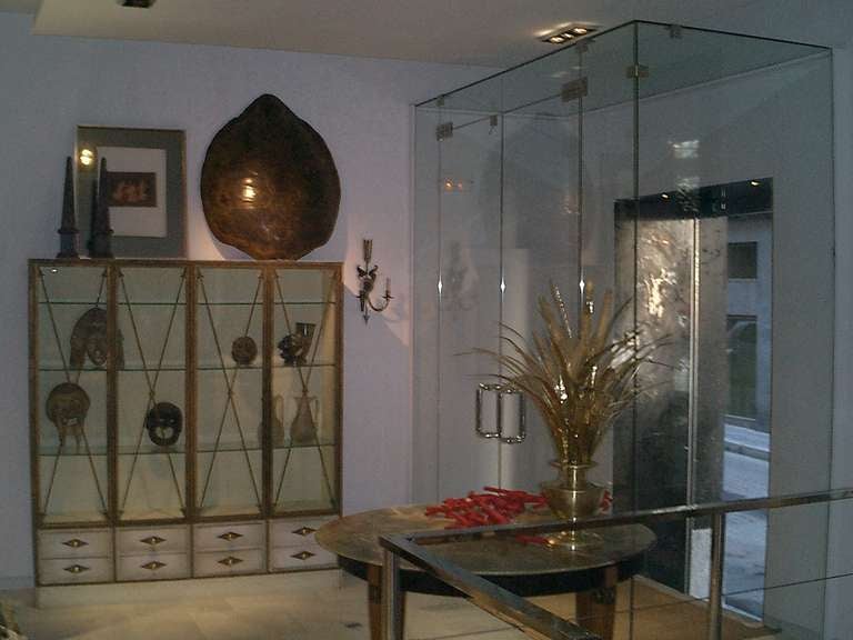 A breakfront bookcase with four glazed doors decorated with gilded iron arrows.