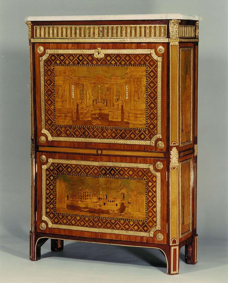 A Louis XVI period  marquetry secrétaire with capriccio scenes of ruins and obelisks evoking landscapes of the artist Hubert Robert,
gilt bronze mounts, original spring locks, green leather cartonnier.
White marble top. Stamped 
