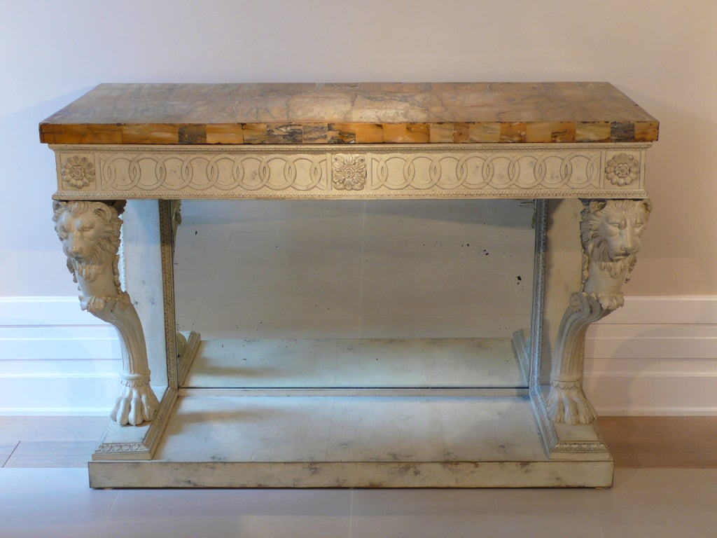 A lacquered console table with decoration of lion's heads and paw feet, Sienna marble top, mirror, circa 1815, Rome.