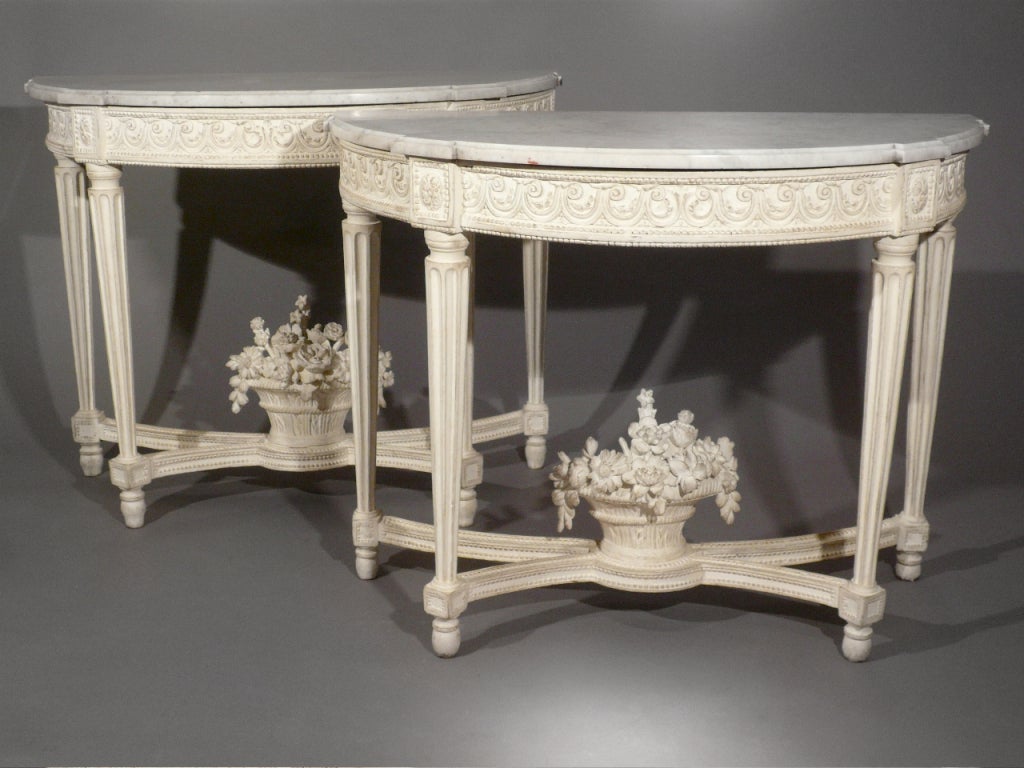 A fine pair of white lacquered consoles with white marble tops, flower basket decoration, Louis XVI period, circa 1780, France.
