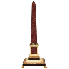 A Grand Tour Porphyry Obelisk With Sienna Marble Paw Feet