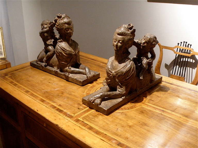 A pair of terra cotta sphinxes with burned patina. France, early 19th century.