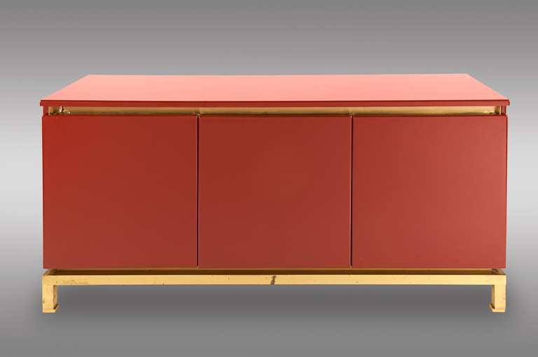 Sideboard by Maison Jansen. Designer Guy Lefevre. Garnet lacquer three door cabinet with brass. The interior with mahogany shelves. 1970