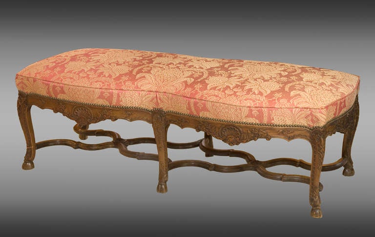Large carved walnut french stool of Regence style. Upholstered french silk. 19th Century.