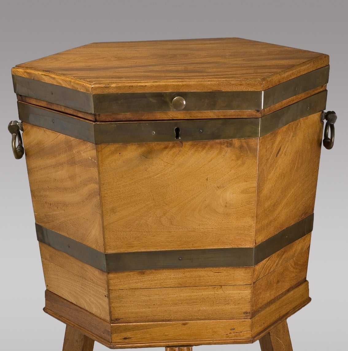 This antique mahogany wine cooler on stand was produced in England, circa1800 during the George III period. It features the original zinc interior, with mahogany exterior and bronze details.