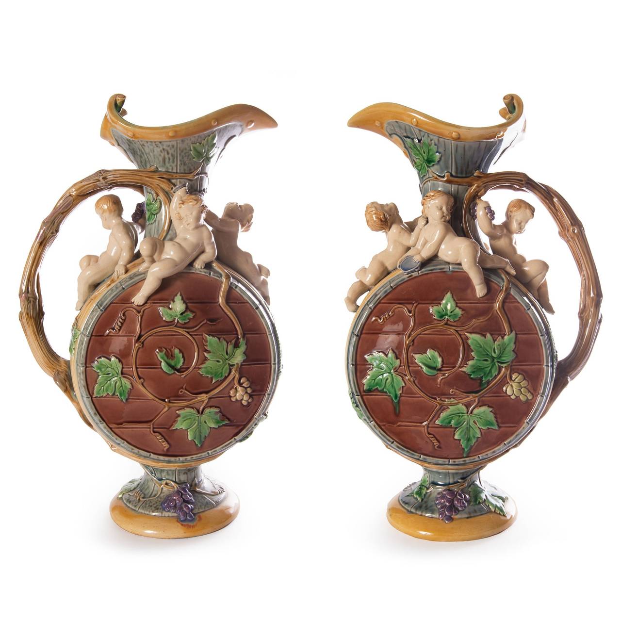 After a design by Hughes Protat, the circular bodies modelled as a barrel with entwined grapevine handles, the shoulders each applied with four Bacchic putti.

These charming antique ewers are an excellent example of fine Victorian majolica ware,