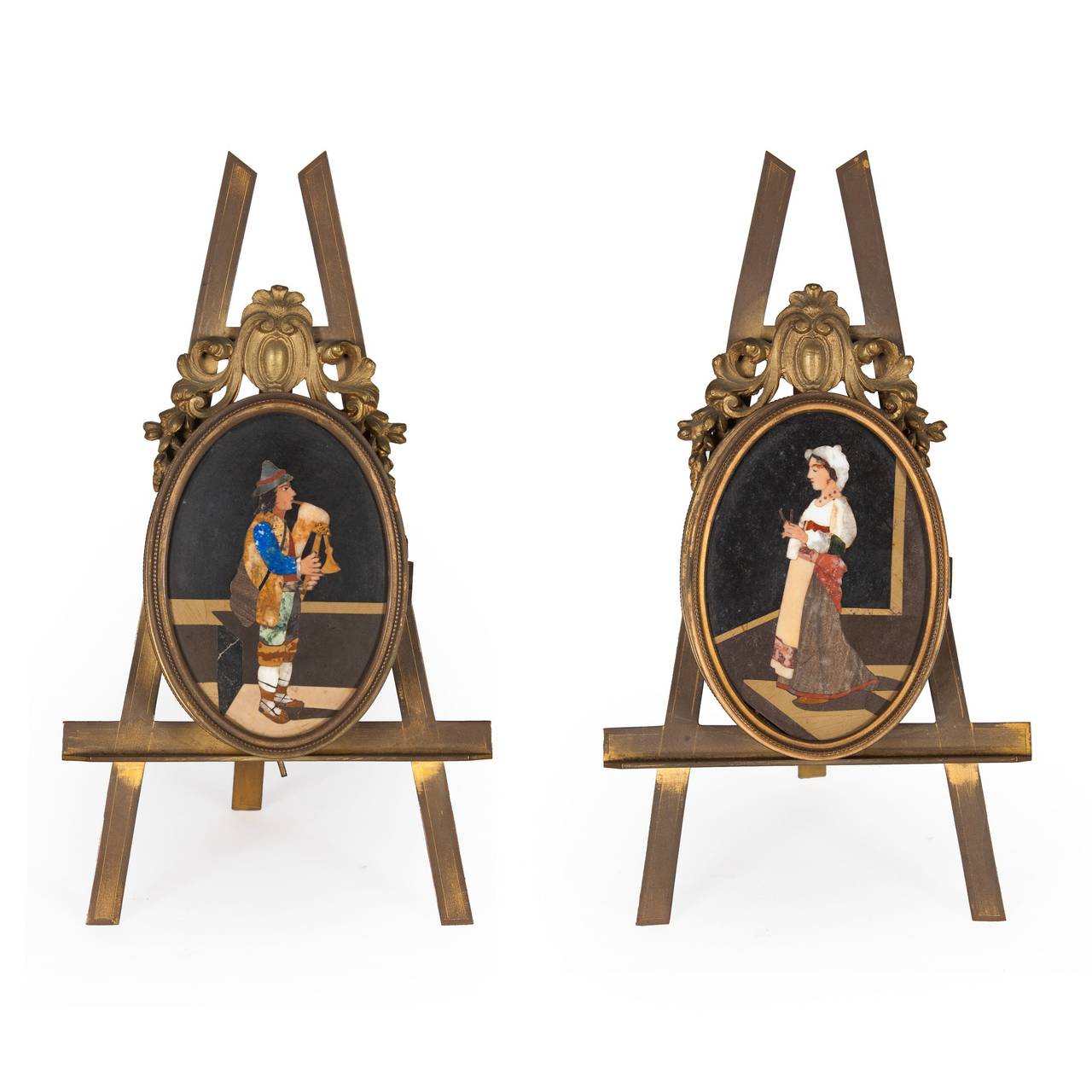 Inlaid with an Italian peasant man playing the bagpipes and a woman knitting, each in gilt metal mount with scroll cresting on a strut stand, opening to reveal a double, glazed frame.