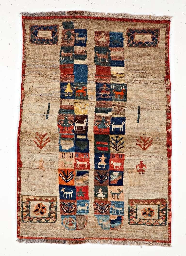 This unique and eye-catching Gabbeh rug is made with extra high pile and extra fine wool yarns, very bright and vivid. This rug shows emblematic characters found in early Gabbeh rugs such as the Lion (honor and victory); the Camel (wealth and