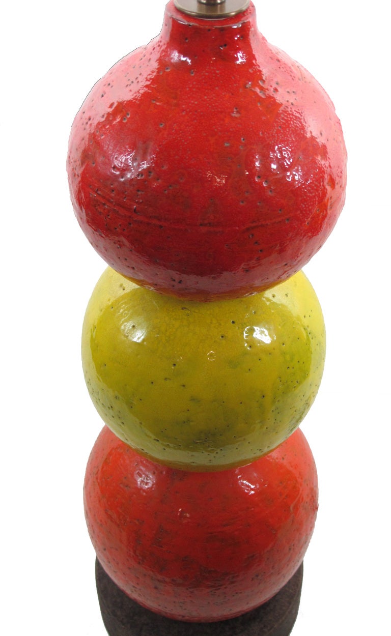Bright colors top to bottom: Red, Yellow, Orange. On a rich chocolate ceramic base. Ceramic only measures 25.75 inches.