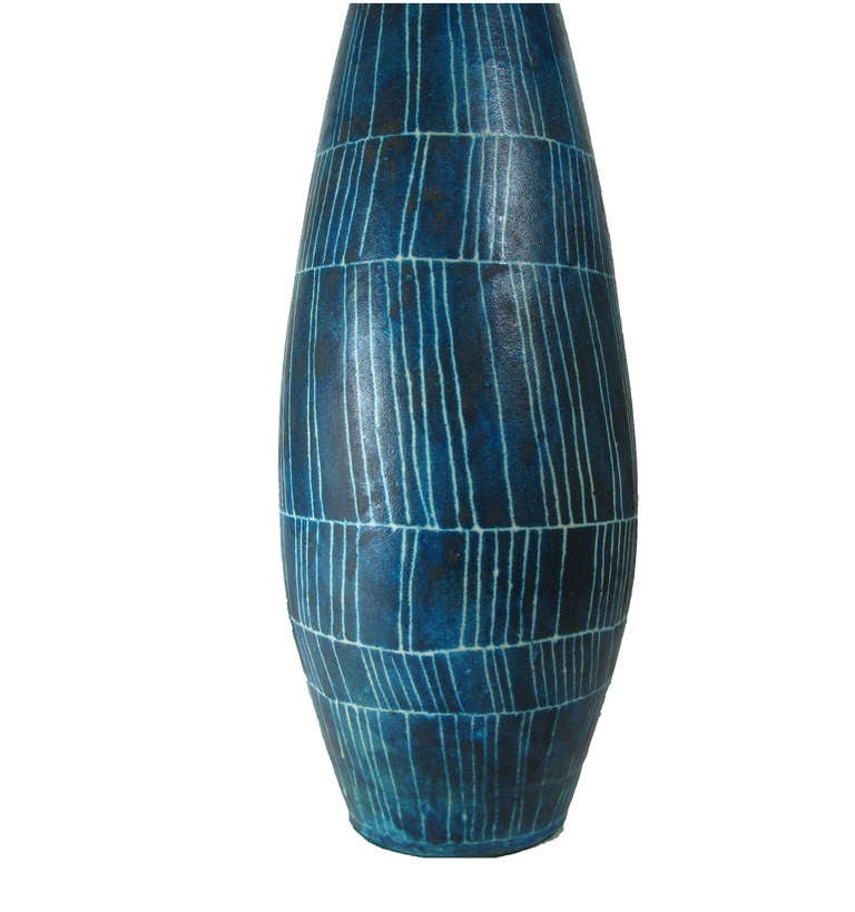 Early bottle shaped hand thrown ceramic lamp by Guido Gambone with sgraffito pattern in white over blue. Rewired for immediate use with a single socket, harp and original blue wood finial. Ceramic is just over 24