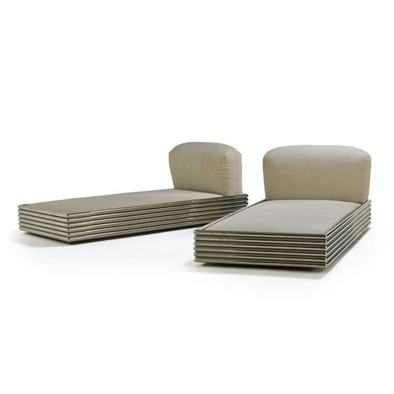 Ultra chic pair of polished stainless steel tubular twin beds with upholstered headrests and concealed casters