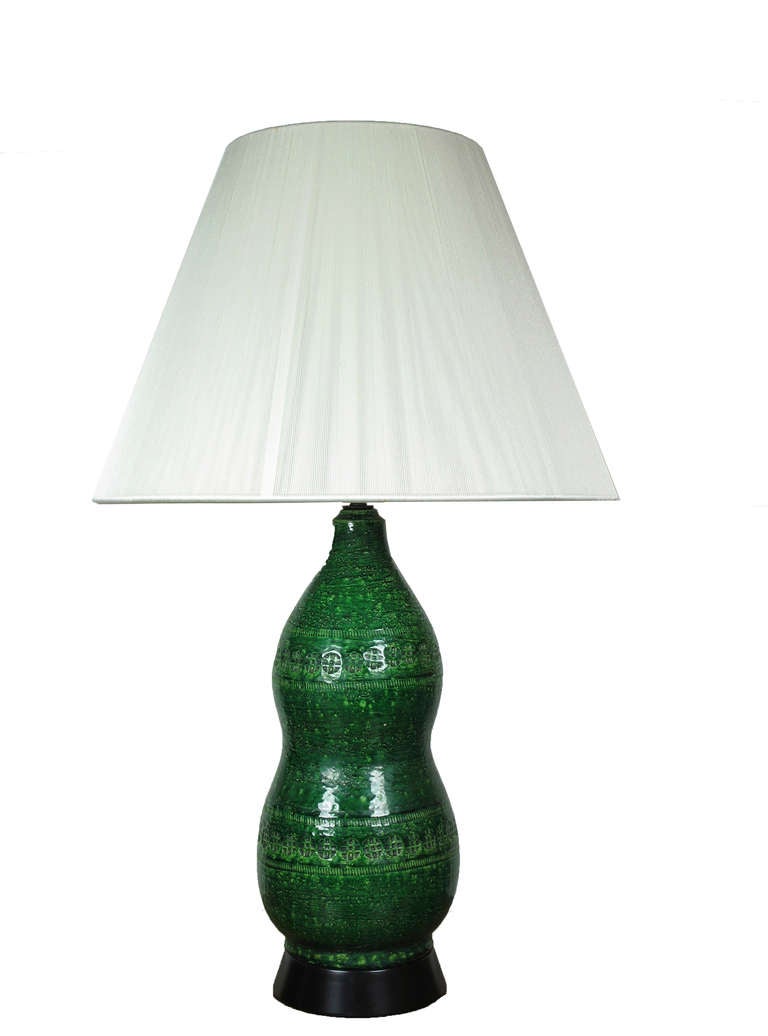 Rich emerald green color with embossed repeating decorative pattern. Marked on underside on ceramic base: 