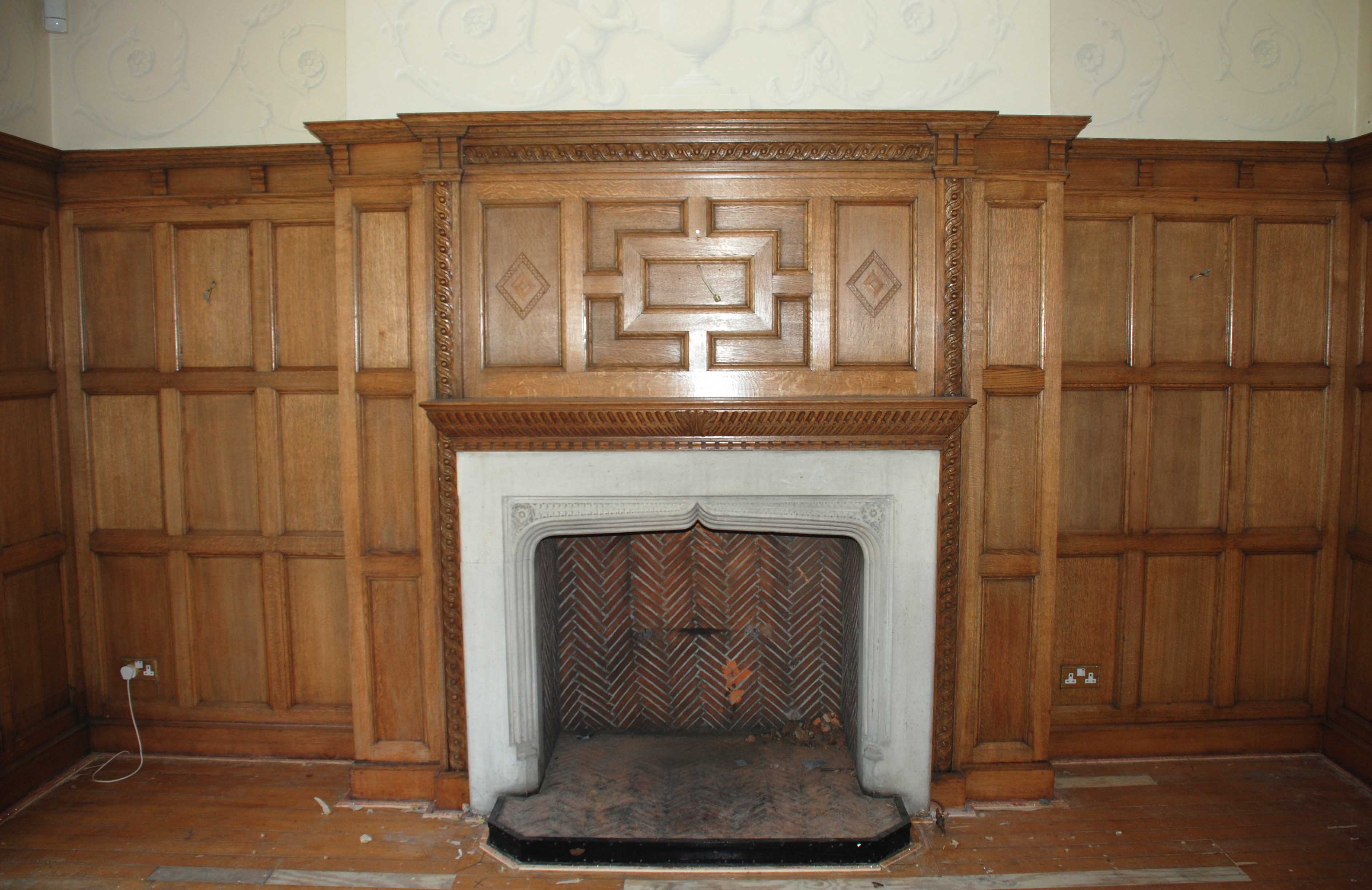 An oak panelled room with stone fireplace For Sale