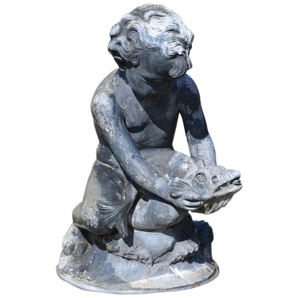 An early 20th century lead fountain in the form of a boy holding a fish