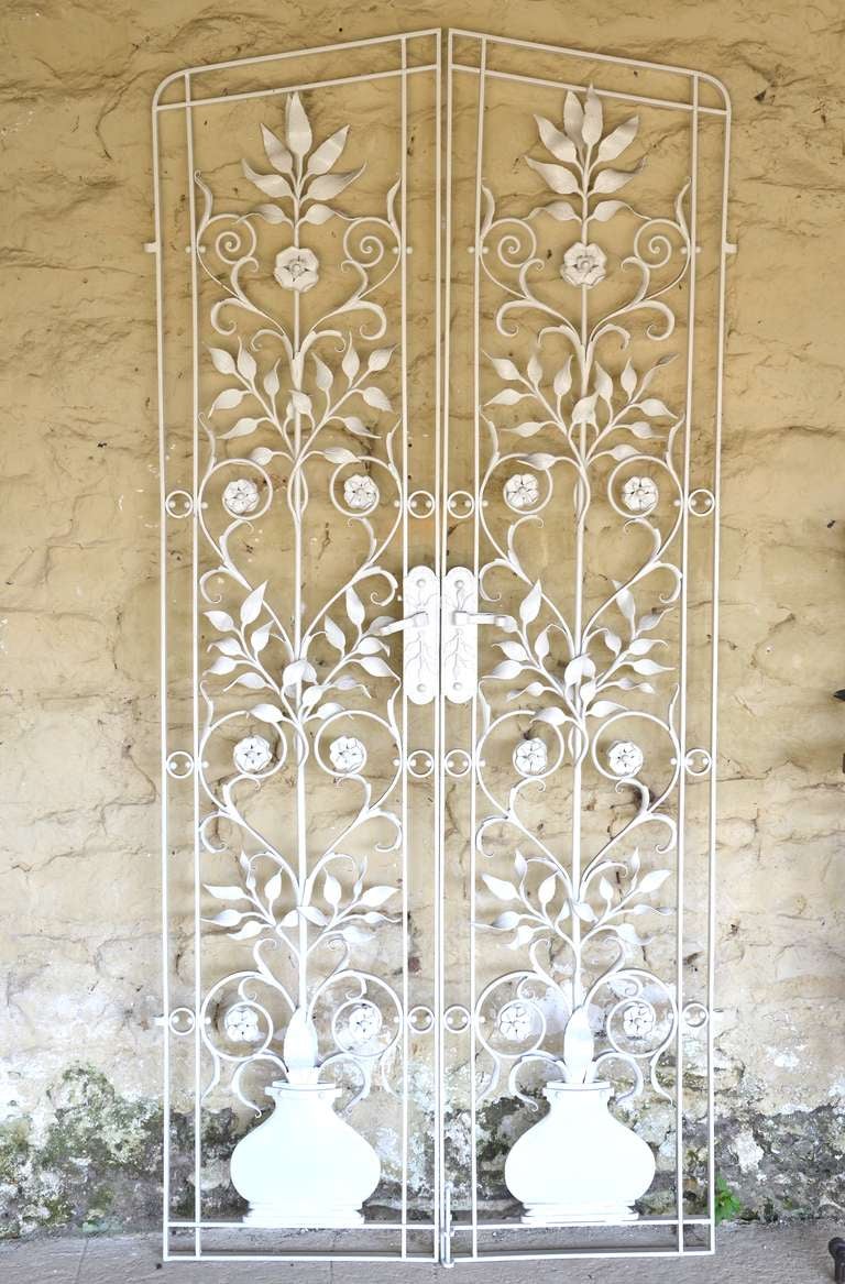 A pair of fine wrought iron garden gates, circa 1890, having foliage and scroll decoration emanating from a bulbous vase. Provenance: Broadhanger House, Hampshire, England.