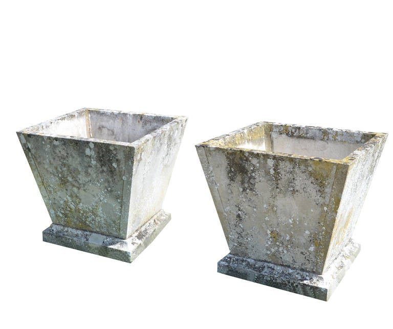 A pair of mid-20th century square stone planters of taper form raised on moulded base and plinth drilled for drainage. 
Two pairs available.