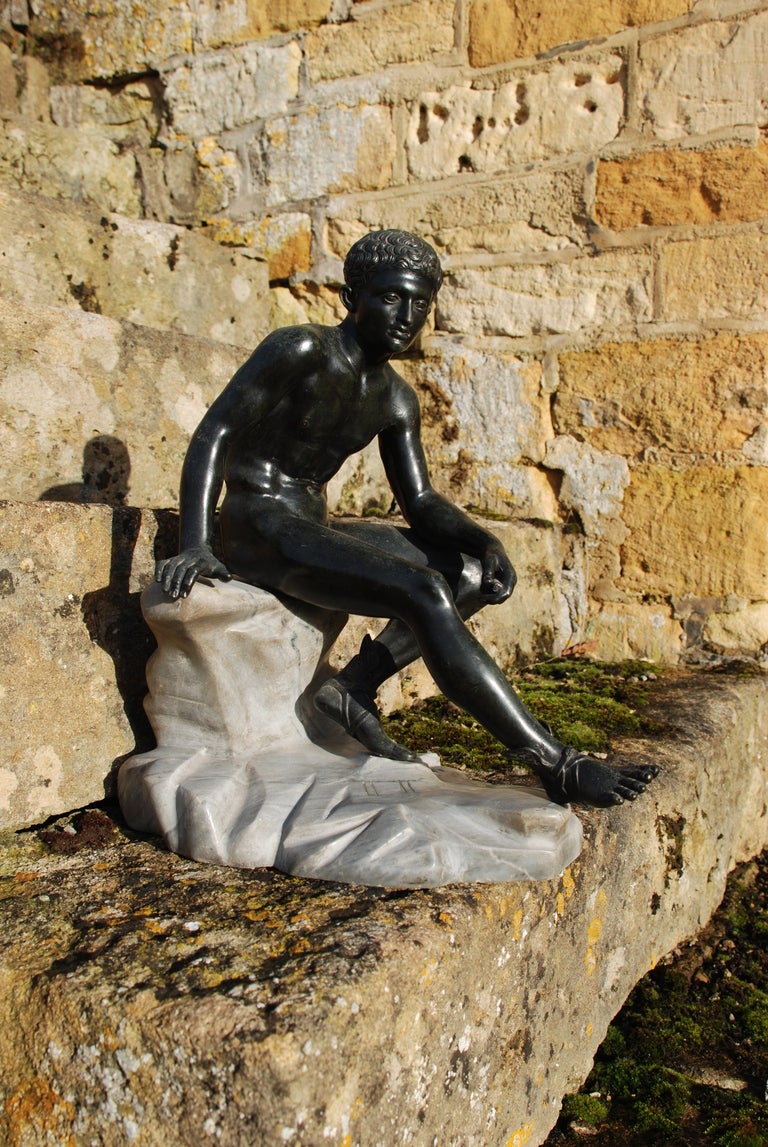 A small scale Neapolitan bronze of the Seated Hermes raised upon a marble rock, circa 1900.  This well cast model is based on the original excavated at Villa dei Papiri, Herculaneum and is attributable to one of the foundaries operating in and