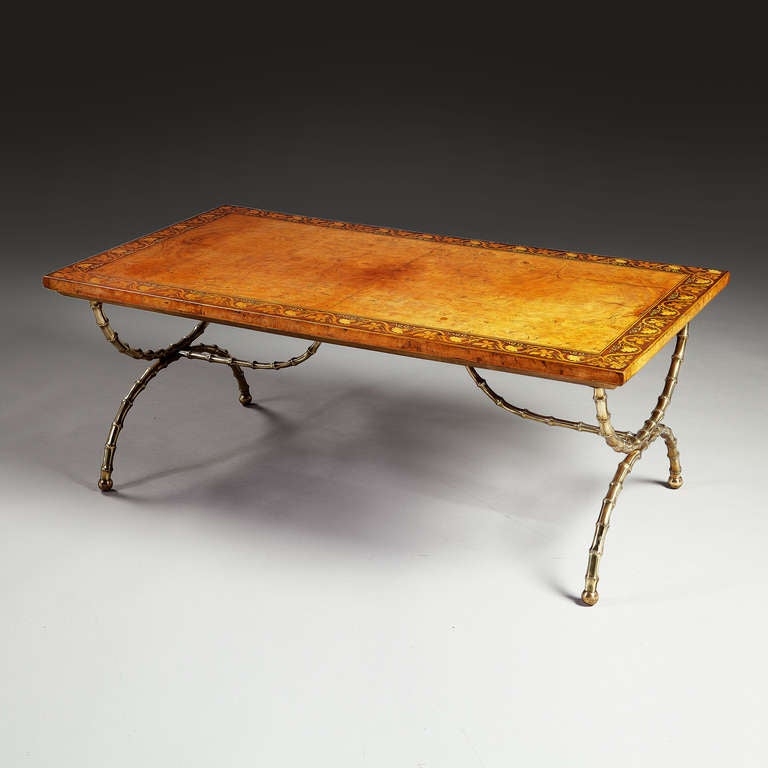 A fine early twenieth century low table with mounted panel of Charles X marquetry, raised on polished brass X frame and bamboo simulated legs.