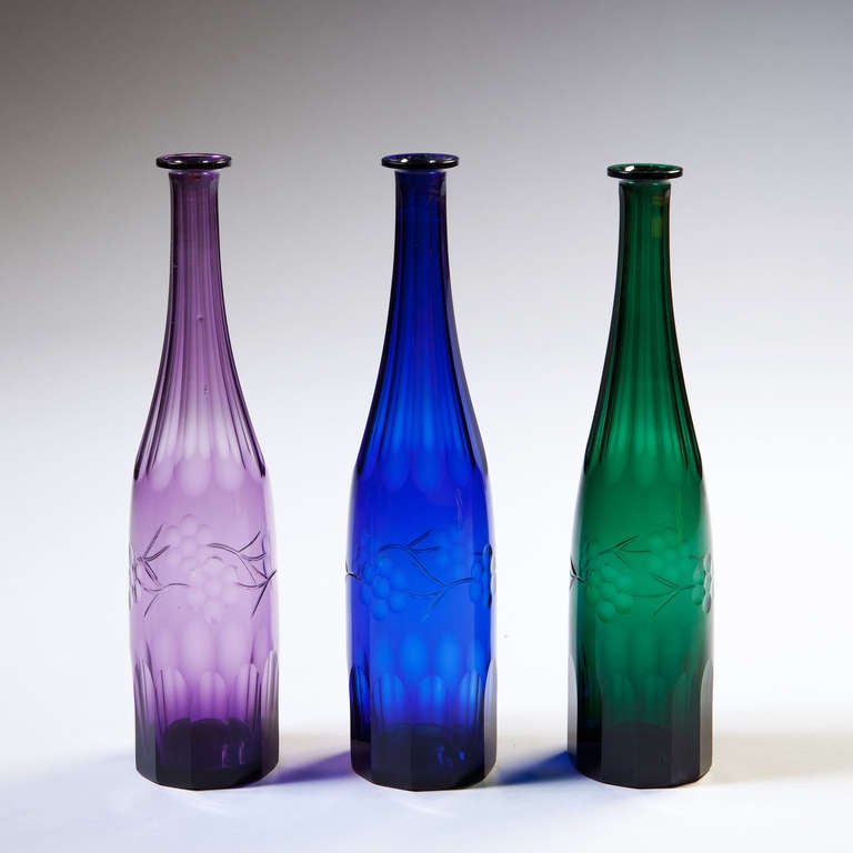 A fine set of three mid 19th century coloured glass bottles.
