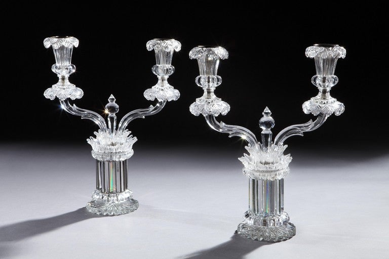 A very rare pair of fine William IV cut glass two light candelabra incorporating straight cut prisms above a star cut base and below layers of finely cut tiers of glass rings, the whole supporting solid glass arms with faceted cutting, each arm